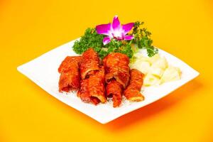 Crispy Fried Intestines Roll with rice and vegetable served in plate isolated on orange background side view of hong kong food photo