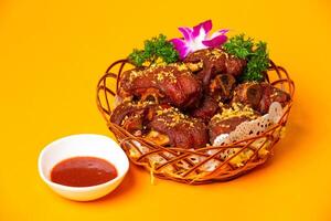 Crispy Fried Pig Trotters or pork Knuckle with Red Bean Curd served in plate isolated on orange background side view of hong kong food photo