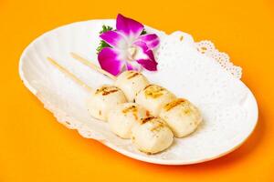 Grilled Sesame Balls Skewers served in plate isolated on orange background side view of hong kong food photo