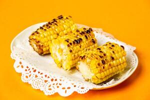 Grilled Corn on the Cob served in plate isolated on orange background side view of hong kong food photo