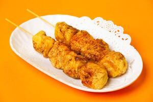 Roasted Tofu skewers served in plate isolated on orange background side view of hong kong food photo