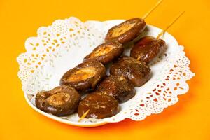 Roasted Shiitake Mushroom Skewers served in plate isolated on orange background side view of hong kong food photo