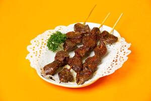 Grilled Lamb Skewers tikka kabab served in plate isolated on orange background side view of hong kong food photo