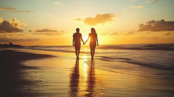 Couple holding hands on the beach at sunset photo