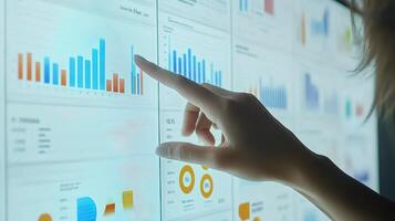 A person pointing at a screen with graphs and charts photo