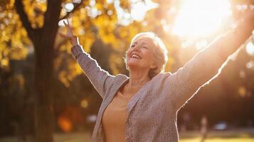 Joyful Senior Woman Dancing in Sunny Park Surrounded by Nature photo