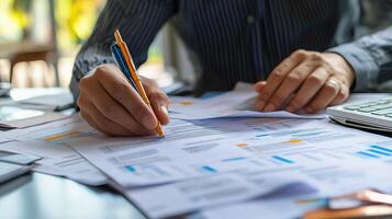 Businessman's hands writing on papers with pen and calculator photo