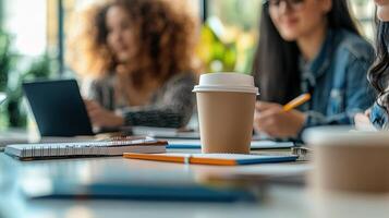 A group of people sitting at a table with a coffee cup photo