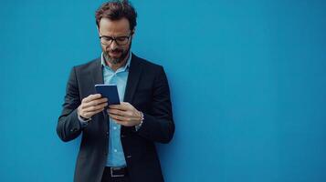 Businessman Using Smartphone Against a Bright Blue Background photo