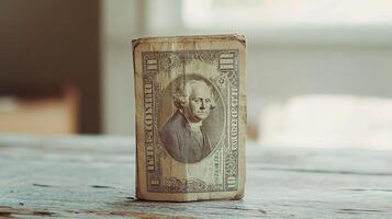 A dollar bill sitting on top of a wooden table photo