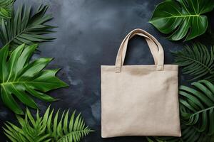 Eco-friendly tote bag mockup surrounded by lush green leaves on dark surface photo
