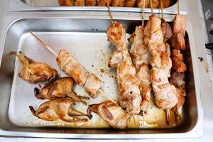 Delicious Grilled Meat Skewers paired with Roasted Quail served elegantly on a Food Tray photo