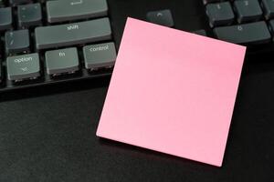 Blank sticky note on keyboard. Copy space for text on sticky note. photo