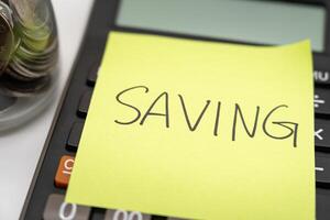SAVING text with sticky note on calculator. financial concept. Saving money concept. Retirement concept. Pension calculation photo