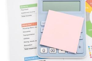 Blank Sticky note with calculator background. Financial data analyzing. Working on desk photo