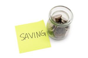 SAVING text with sticky note and Coins in glass money jar isolated on white background, financial concept. Saving money concept. photo