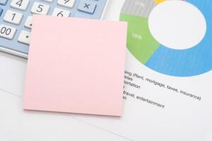 Blank Sticky note with calculator background. Financial data analyzing. Working on desk with using calculator, finance accounting. photo