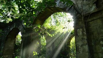 Sunbeams shine through the arches of an old stone building photo