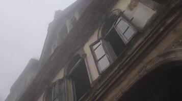 A building with windows and a foggy sky photo