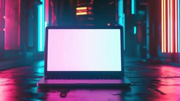 A laptop sitting on a dark floor with neon lights photo