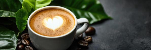 Coffee cup with heart shape latte art on dark stone background photo