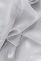 Chic Abstract Background Silk Sheer Fabric, Silver Chiffon. metallic sheen of the fabric. Soft flowing waves of the material. top vertical view photo