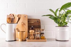 Beautiful kitchen background with spice storage area, cutting wooden boards, green plant in a chic indoor pot. white brick wall.. Front view. photo