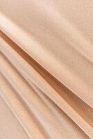 Chic vertical gold fabric background with glitter. parallel soft folds. Beautiful fabric texture. design. layout. Festive background. photo