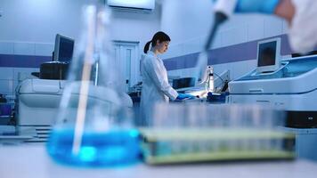 Close-up of test tubes with liquid and pipette pouring substance in modern laboratory with advanced equipment. The concept of research and experiments in a high-tech scientific laboratory video