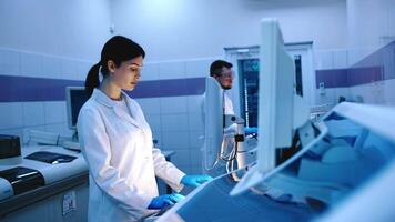 Research scientists work in a laboratory with modern equipment. Analyzes samples and genetic material with special machines in a modern laboratory video