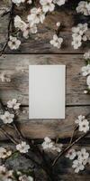 Vintage inspired still life with empty white frame and flowering branches on wooden background photo