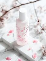 Elegant cherry blossom cosmetic bottle display on marble background for product design photo