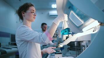 Doctors work in a modern laboratory with advanced equipment and an analyzer. The concept innovative technologies and top-notch equipment for precise scientific research video