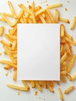 Creative blank paper surrounded by crispy french fries for food concept design photo