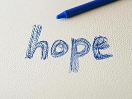 Close up of the word hope handwritten in blue by child for inspiration and positivity photo