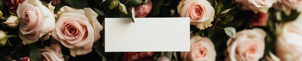 Soft romantic composition with white greeting card surrounded by pink roses photo