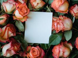 Blank white card on floral background with pink and orange roses for romantic invitations photo