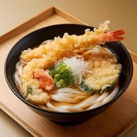 A delicious bowl of Japanese udon noodles topped with tempura shrimp and green onions. photo