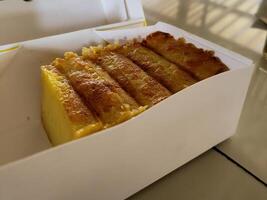 A beautiful and delicious cake made from tapioca flour, sugar, coconut milk and chicken eggs in a paper box. photo