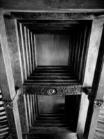 The ceiling of a traditional Javanese luxury house is made of wood and decorated with carved ornaments. photo