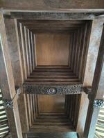 The wooden ceiling of a traditional Javanese luxury house and decorated with carved ornaments. photo