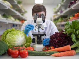 A scientist in a lab coat examines vegetables under a microscope in a research setting. photo