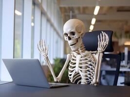 A humorous skeleton figure animatedly typing on a laptop in a modern office setting. photo