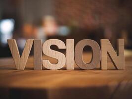 Stylish wooden letters forming the word 'VISION' on a rustic tabletop, evoking creativity and inspiration. photo