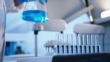 Blue medical liquid in a flask, adding drops from a pipette. Scientific experiments with chemical substances. Banner, advertising. No people video