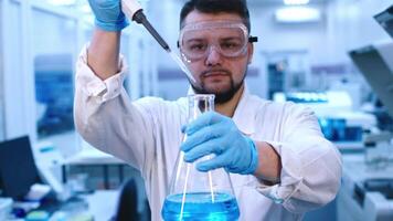 Man scientist in glasses works with high-tech equipment in a modern laboratory, analyzing biological material and conducting experiments video