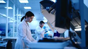 Two Diverse Scientists use lab equipment for an experiment, working with test tubes and samples. Scientific research and experiments using cutting-edge technology in the laboratory video