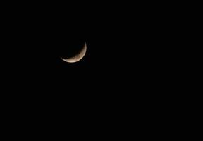 Crescent against dark night sky background with space for Ramadan, Isolated new moon rising or waxing crescent on black background concept for symbolizes of growth, hope photo