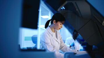 Team of doctors analyze a blue liquid in a laboratory. Concept of research using cutting-edge technology to analyze chemical substances. Blue Background video