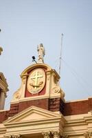 A building with a clock and a statue on top photo